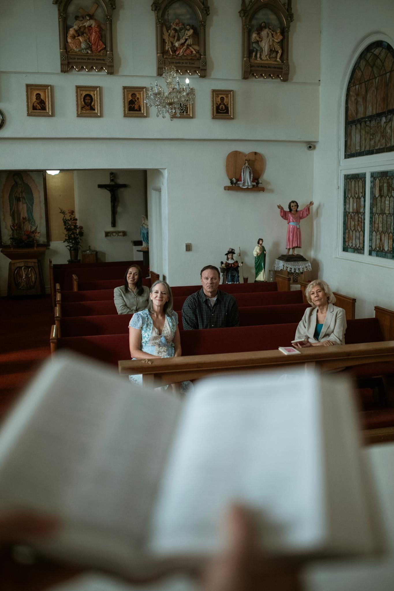 Individuals sitting in a church pew during a prayer session.
